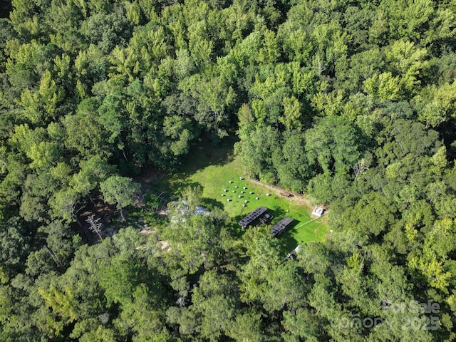 birds eye view of property featuring a forest view