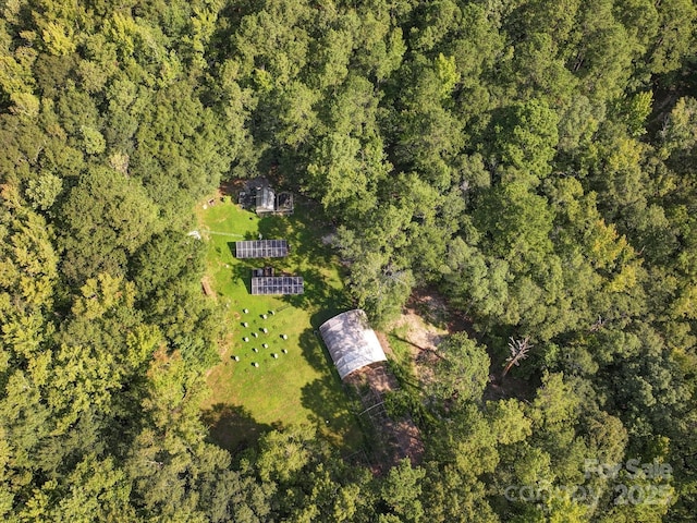 birds eye view of property featuring a forest view