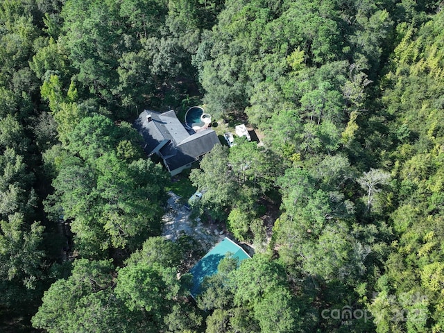 drone / aerial view with a wooded view