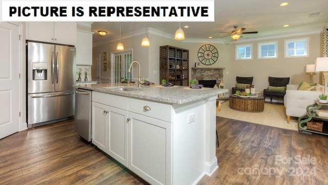 kitchen featuring appliances with stainless steel finishes, white cabinets, a stone fireplace, ceiling fan, and sink