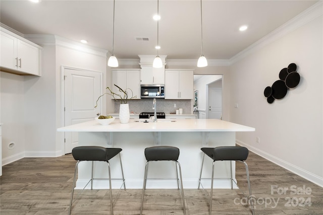 kitchen featuring pendant lighting, white cabinets, an island with sink, and dark wood-type flooring