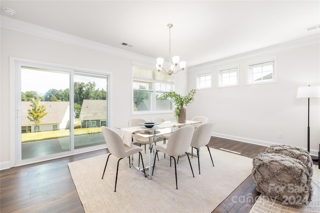 dining space with dark wood-type flooring, a chandelier, and ornamental molding