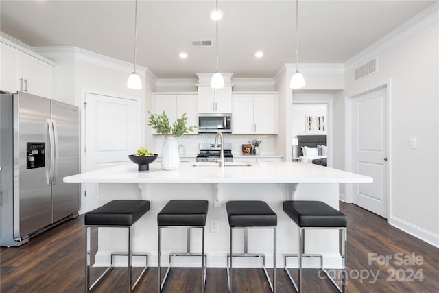 kitchen with a kitchen island with sink, appliances with stainless steel finishes, hanging light fixtures, and dark hardwood / wood-style flooring