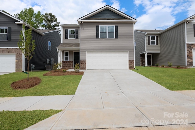 view of front facade with a garage, a front lawn, and central AC