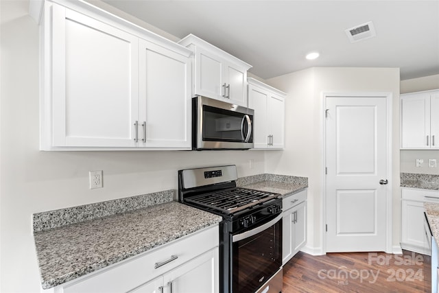 kitchen with stainless steel appliances, dark hardwood / wood-style floors, light stone countertops, and white cabinetry