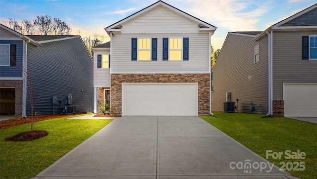 view of front of house with stone siding, concrete driveway, a lawn, and central air condition unit