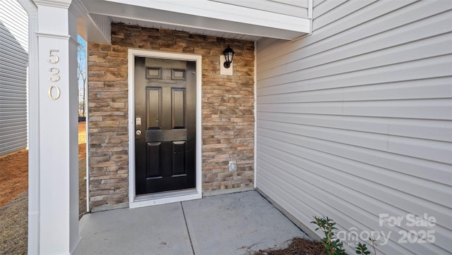 view of exterior entry featuring stone siding