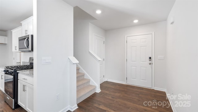 interior space with recessed lighting, dark wood-style flooring, stairway, and baseboards