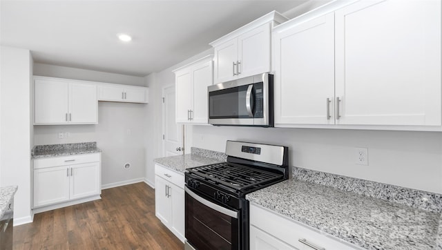 kitchen featuring baseboards, dark wood-type flooring, light stone countertops, stainless steel appliances, and white cabinetry