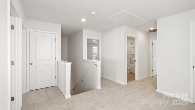 hallway featuring visible vents, attic access, light carpet, an upstairs landing, and baseboards