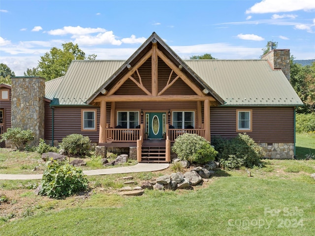 log home featuring a porch and a front lawn