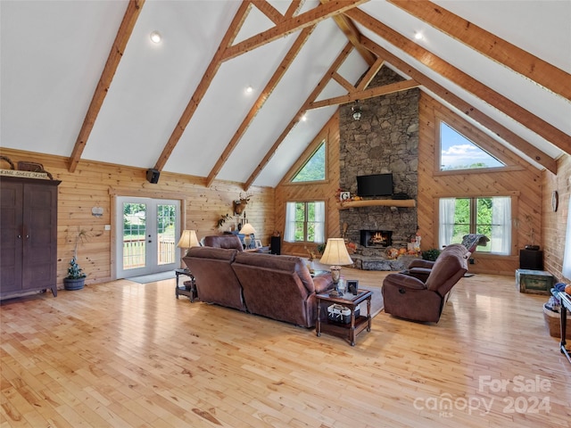 living room with a wealth of natural light, light hardwood / wood-style flooring, and high vaulted ceiling