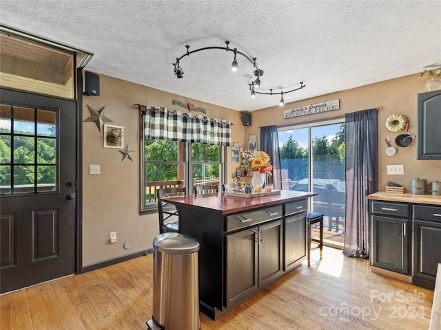 kitchen featuring a center island, plenty of natural light, light hardwood / wood-style floors, and a textured ceiling