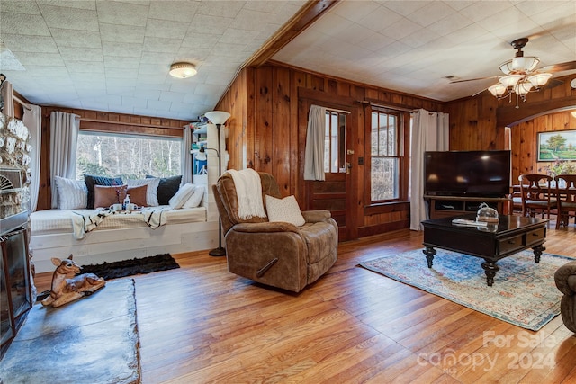 living room featuring wooden walls, light hardwood / wood-style flooring, and plenty of natural light