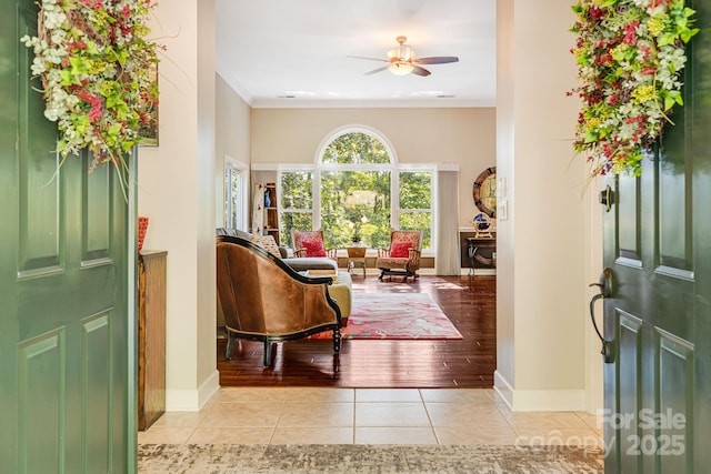 tiled entryway featuring ornamental molding and ceiling fan