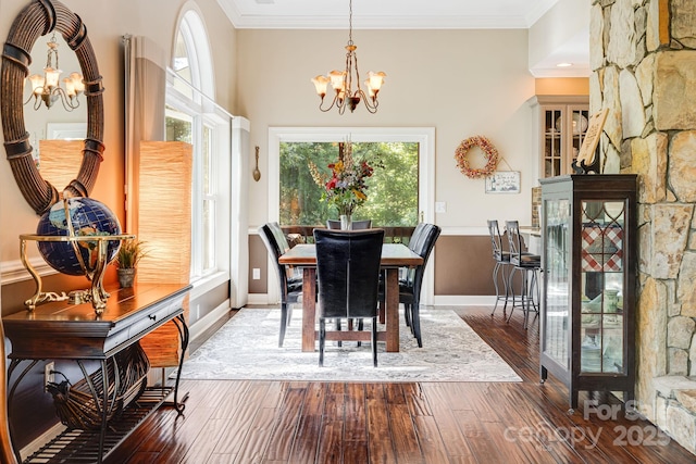 dining room with hardwood / wood-style flooring, crown molding, and an inviting chandelier