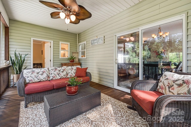 sunroom / solarium featuring ceiling fan with notable chandelier