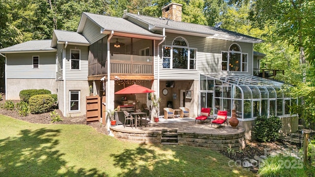 back of house with a patio, a sunroom, and a lawn