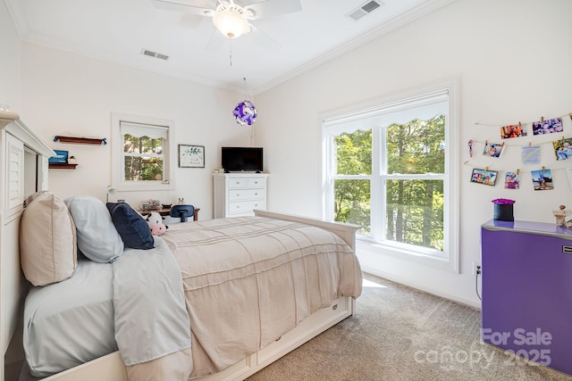 carpeted bedroom with ornamental molding and ceiling fan