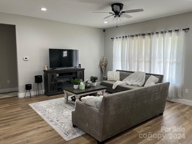 living room featuring hardwood / wood-style floors, a fireplace, and ceiling fan