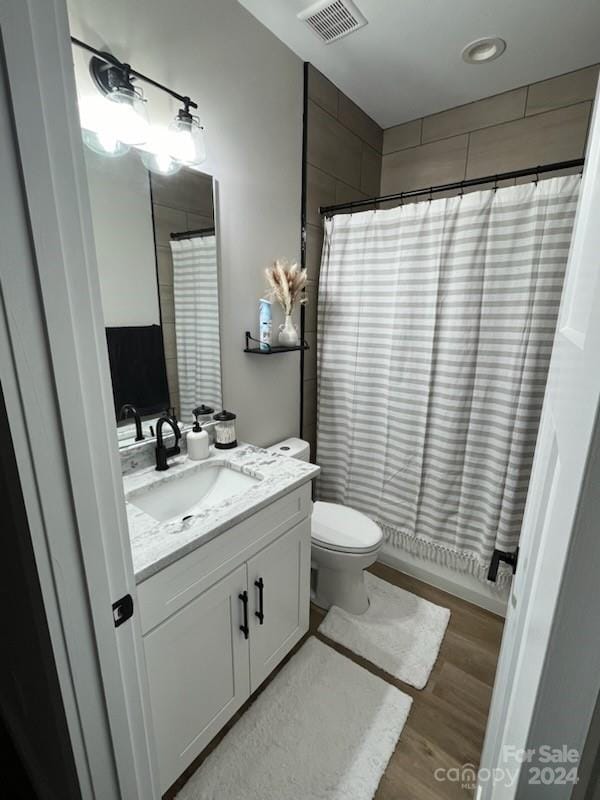 bathroom with vanity, hardwood / wood-style flooring, and toilet