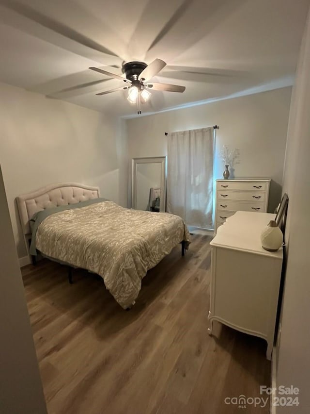 bedroom featuring dark wood-type flooring, crown molding, and ceiling fan