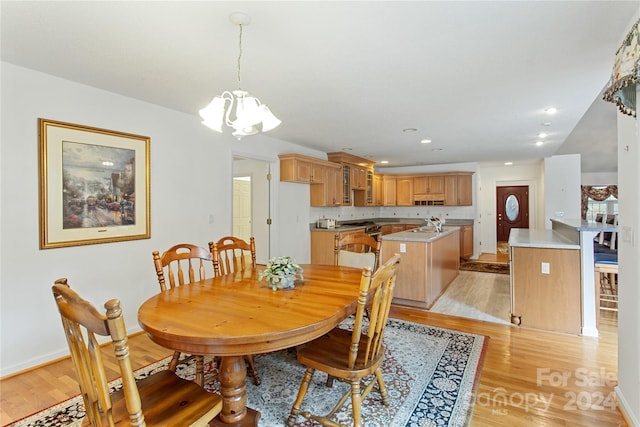 dining room featuring light hardwood / wood-style flooring, a chandelier, and sink