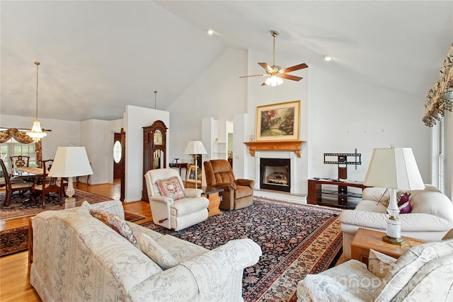 living room featuring ceiling fan, light hardwood / wood-style flooring, and high vaulted ceiling