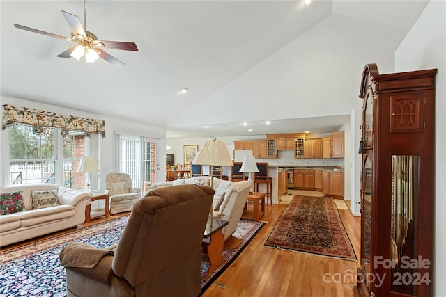 living room featuring high vaulted ceiling, light hardwood / wood-style flooring, and ceiling fan