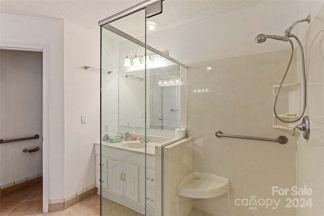 bathroom with a textured ceiling, tile patterned floors, and an enclosed shower