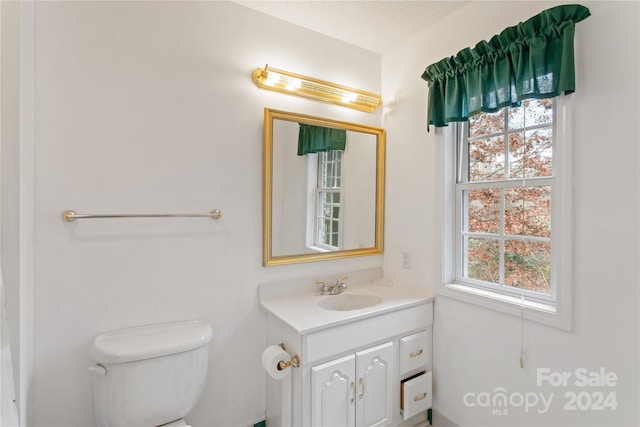 bathroom with vanity, toilet, and a textured ceiling