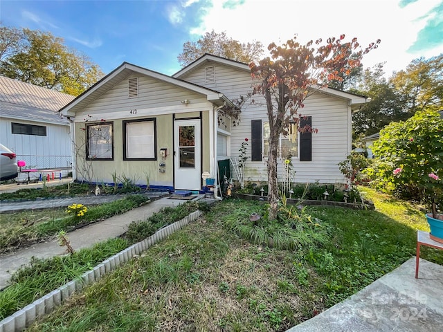 bungalow-style home with a front lawn