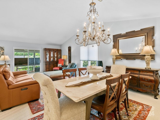 carpeted dining room with a healthy amount of sunlight, vaulted ceiling, and an inviting chandelier