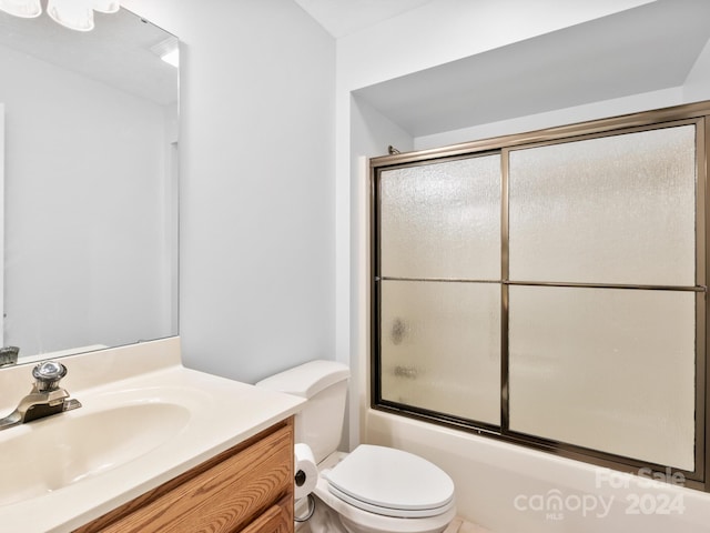 full bathroom with bath / shower combo with glass door, vanity, and toilet