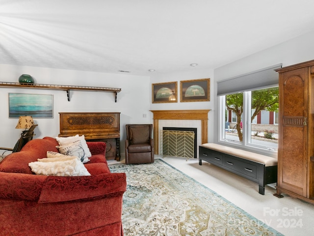 carpeted living room featuring a tiled fireplace