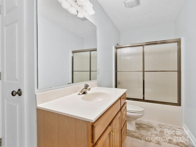 full bathroom with vanity, toilet, tile patterned floors, and bath / shower combo with glass door