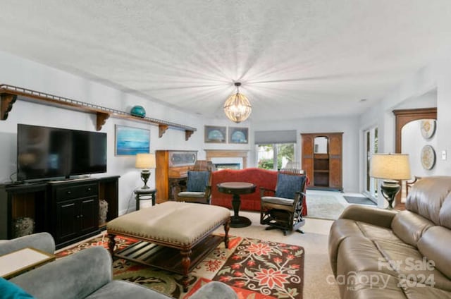 living room with light carpet, a fireplace, and a chandelier