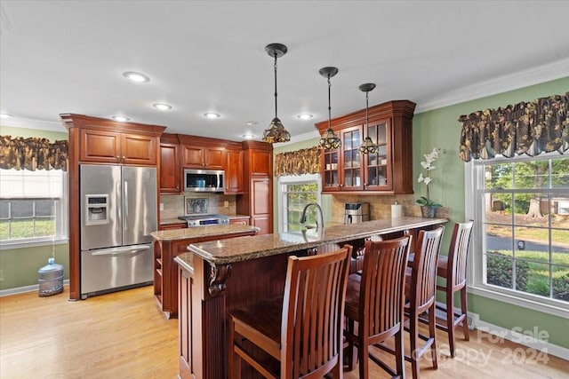 kitchen featuring a wealth of natural light, stainless steel appliances, and kitchen peninsula