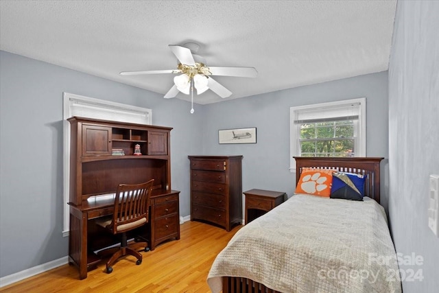 bedroom featuring ceiling fan, a textured ceiling, and light hardwood / wood-style flooring