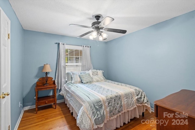 bedroom featuring a textured ceiling, hardwood / wood-style flooring, and ceiling fan