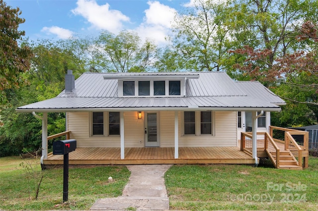 view of front of property with a wooden deck and a front lawn