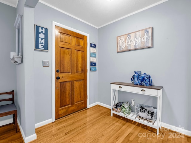 entrance foyer featuring crown molding and hardwood / wood-style flooring