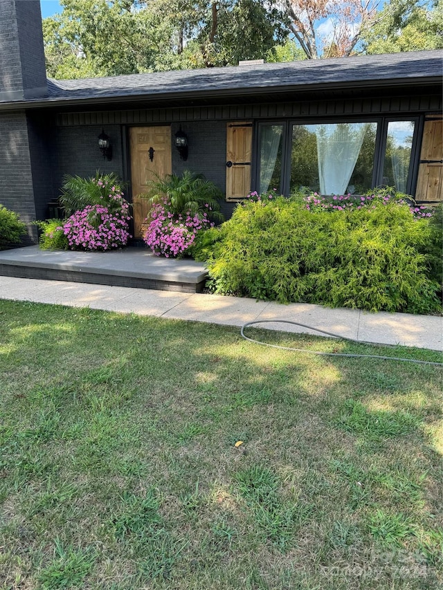 doorway to property with a lawn