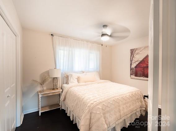 bedroom featuring dark hardwood / wood-style floors, ceiling fan, and a closet