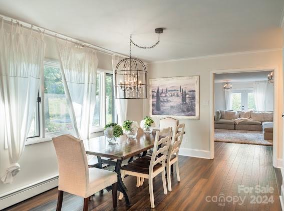 dining room featuring ornamental molding, dark hardwood / wood-style floors, a chandelier, and a baseboard radiator