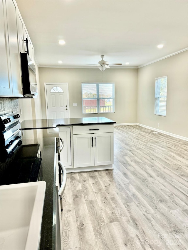 kitchen with white cabinetry, stainless steel appliances, light hardwood / wood-style flooring, decorative backsplash, and ornamental molding