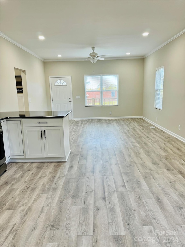 unfurnished living room with crown molding, ceiling fan, and light wood-type flooring