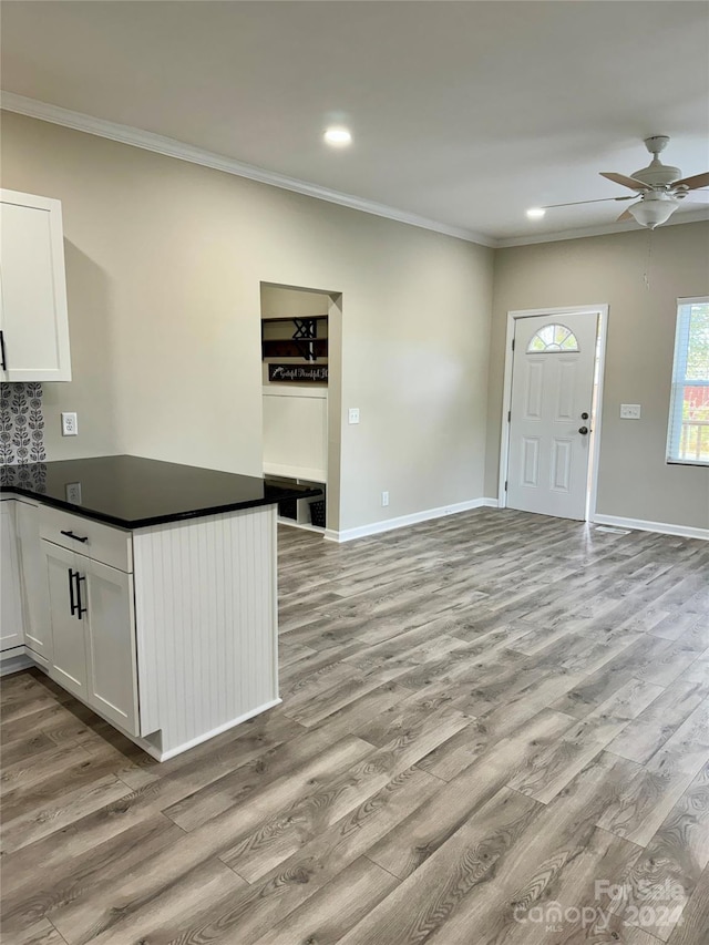 kitchen featuring white cabinets, light hardwood / wood-style floors, and crown molding