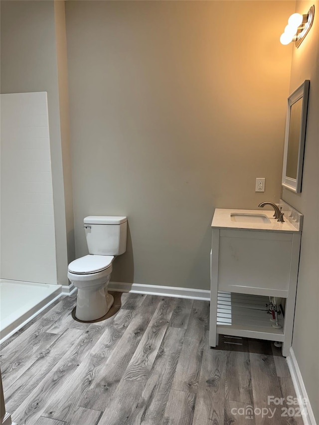 bathroom featuring vanity, hardwood / wood-style flooring, and toilet