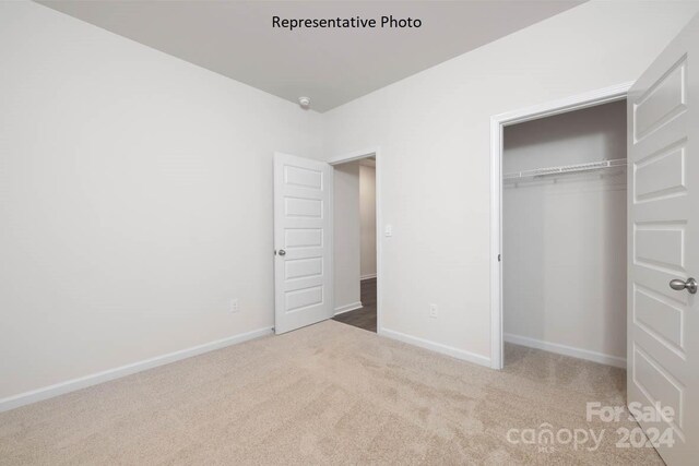 unfurnished bedroom with carpet and a closet